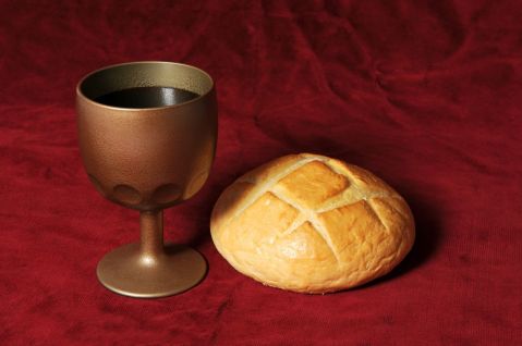 Communion-elements-represented-by-bread-and-wine-over-a-red-background